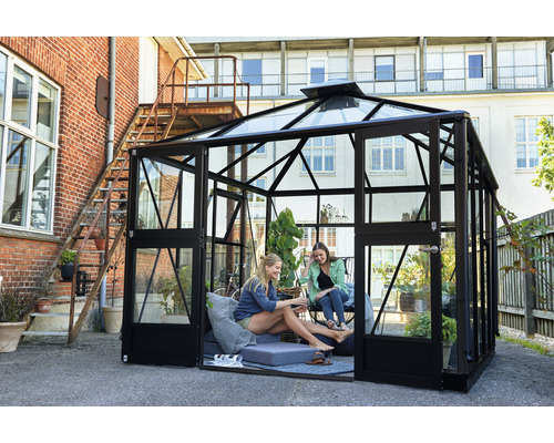 Gewächshaus mit Glaswänden und schwarzem Rahmen im Garten