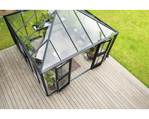 Gewächshaus mit Glaswänden und Pflanzen auf Holzterrasse