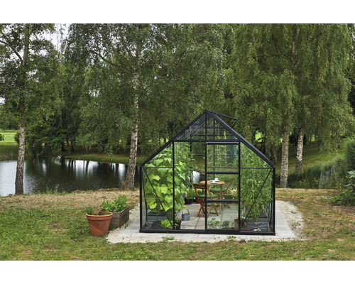 Gewächshaus im Garten mit Pflanzen, Tisch und Stühlen