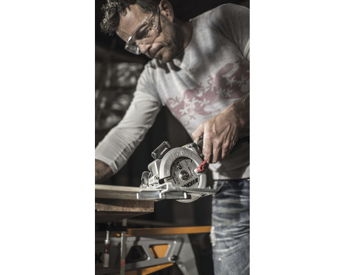 Mann sägt Holzbrett mit einer Handkreissäge von Worx