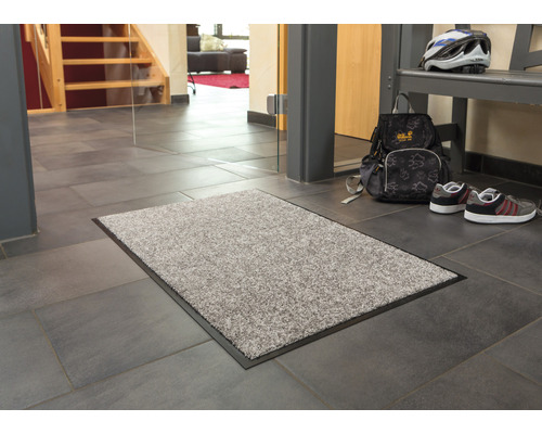 Fußmatte im Eingangsbereich eines Hauses mit Fliesenboden.