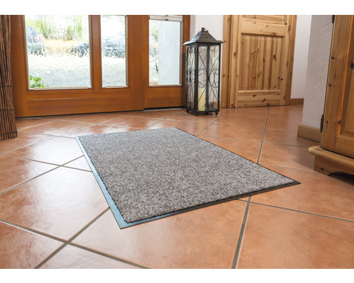 Fußmatte im Eingangsbereich eines Hauses auf Fliesenboden.
