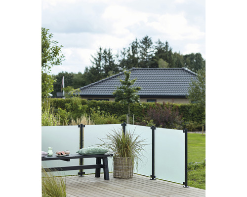 Terrasse mit Sichtschutz aus Glas, Sitzbank und Pflanzkorb vor einem Haus