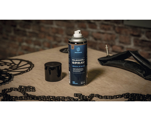 Bike Brooz Silikonspray Dose auf einer Werkbank mit Fahrradteilen