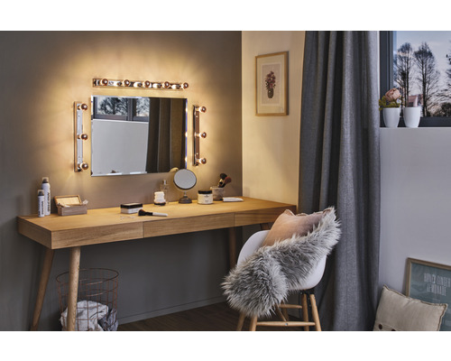 Helles Zimmer mit Schminktisch, Spiegel mit Beleuchtung und Stuhl mit Kissen