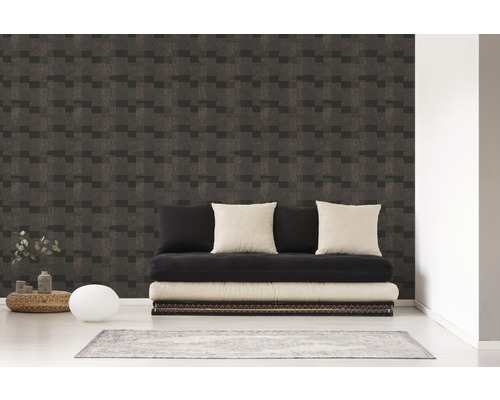 Wohnraum mit einer Wand, die mit einer Tapete mit geometrischem Muster versehen ist, und einem schwarzen Futon