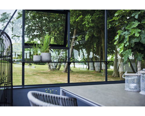 Ansicht eines Gewächshauses mit Pflanzen, Tischen und Stühlen