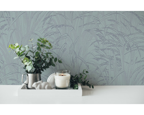 Nahaufnahme einer Wand mit botanischer Tapete, einem Tablett mit Dekorationen und einer Vase mit Eukalyptus.