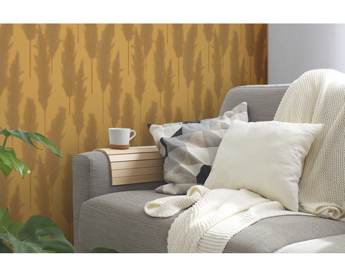 Graues Sofa mit Kissen und Decke, Beistelltisch mit Tasse und gemusterter Tapete