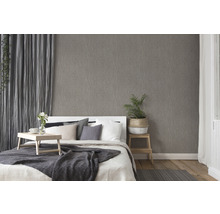 Schlafzimmer mit gemusterter Tapete, Bett und Vorhängen für eine gemütliche Atmosphäre
