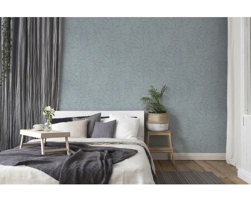 Schlafzimmer mit Bett und Wandtapete mit Pflanzenmuster