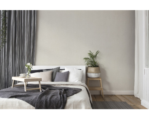 Schlafzimmer mit Bett, Kissen, Überwurf, Vorhängen und Zimmerpflanze für eine gemütliche Atmosphäre.