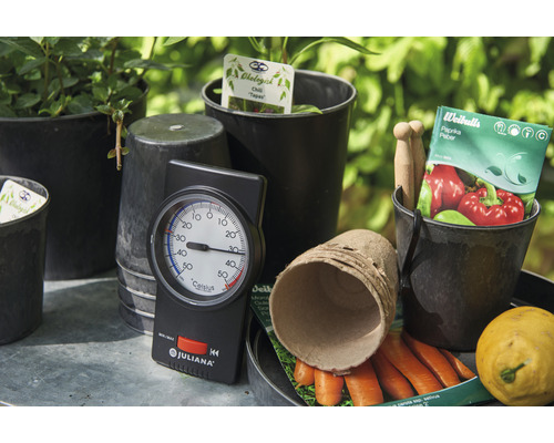 Gartenszene mit Pflanzen, Töpfen, Thermometer der Marke Juliana, Samen und Gemüse