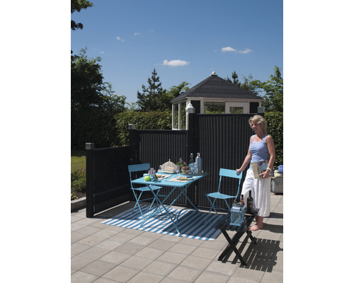 Gartenszene mit Tisch, Stühlen, Sichtschutzzaun und Gartenhaus