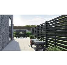 Terrasse mit Holzzaun, Sitzbank und Tischgruppe im Garten.