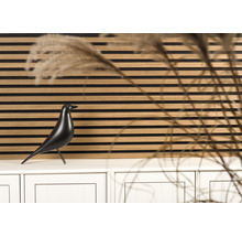 Dekoratives Wandpaneel mit einer schwarzen Vogelstatue auf einem Schrank