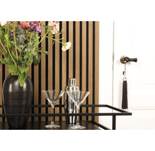 Dekoratives Interieur mit Barwagen, zwei Martini-Gläsern, Cocktailshaker, Blumenstrauß, Wandpaneelen und einer Tür