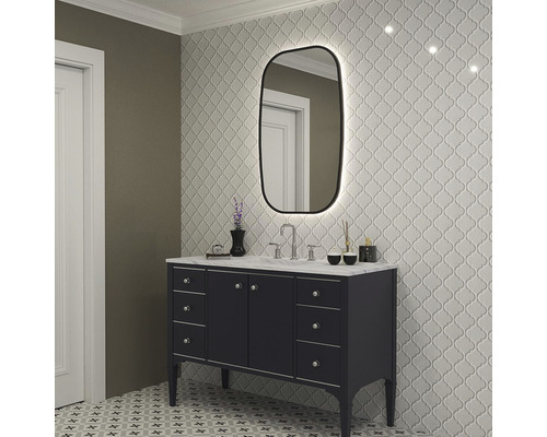 Badezimmer mit Waschtisch, Spiegel mit Beleuchtung und gemusterten Fliesen