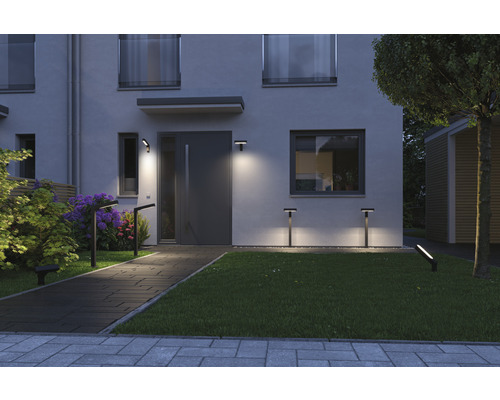 Beleuchtetes modernes Haus mit Gartenweg und Außenleuchten