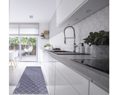 Helle Küche mit Spüle, Armatur, Arbeitsplatte, Fliesenspiegel und einem Teppich mit Muster