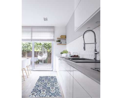 Küchenszene mit einem blauen Teppich mit Muster vor einem weißen Küchenschrank