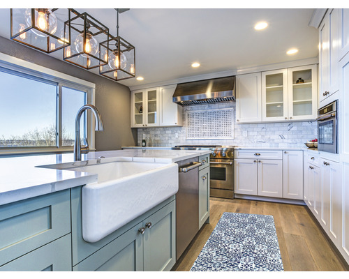 Helle Küche mit Kücheninsel, Spüle, Armatur, Dunstabzugshaube, Küchenschränken und Küchenläufer