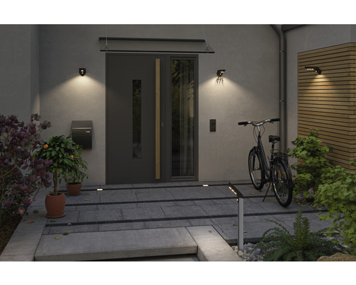 Eingangsbereich eines Hauses mit Haustür, Aussenleuchten, Briefkasten und Fahrrad