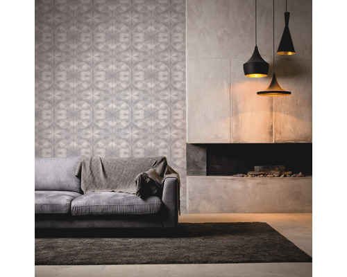 Wohnzimmer mit gemusterter Tapete, Sofa, Teppich, Kamin und Pendelleuchten