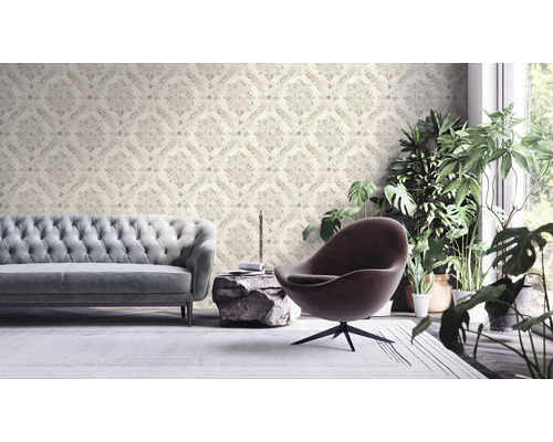 Wohnzimmer mit gemusterter Tapete, Sofa, Sessel und Zimmerpflanzen