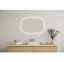 Modernes Badezimmer mit beleuchtetem Spiegel, Waschtisch und Accessoires.