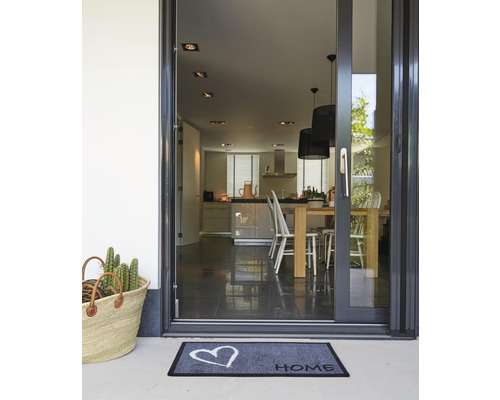 Eingangsbereich mit Fußmatte, Korb und Blick in die Küche