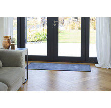 Szene mit einer Fußmatte vor einer Terrassentür, einem Sofa und einem Beistelltisch