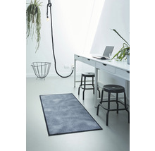 Heller Raum mit Schreibtisch, Stühlen, Lampe und rechteckigem Teppich