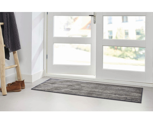 Szene mit Fußmatte vor einer Tür, Leiter, Schuhen und Kleidung