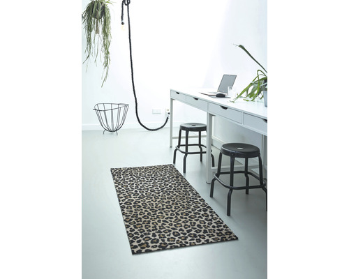 Raumansicht mit Teppich mit Tiermuster, Schreibtisch und Dekoration