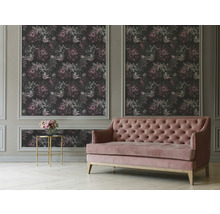 Wohnzimmer mit floral gemusterter Tapete und rosafarbenem Sofa