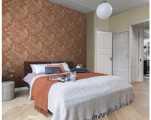 Schlafzimmer mit gemusterter Tapete, Bett und Katze