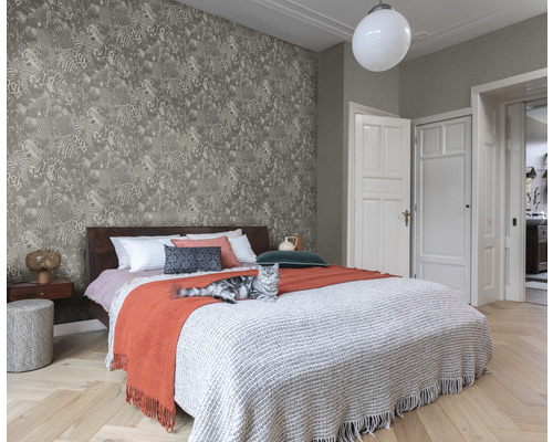 Schlafzimmer mit gemusterter Tapete, Bett und Katze