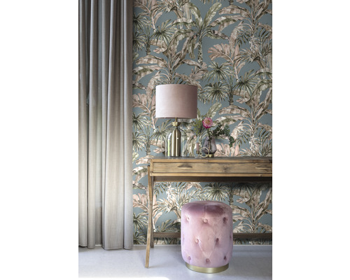 Dekoratives Interieur mit gemusterter Tapete, Tisch, Lampe, Vorhang und Hocker