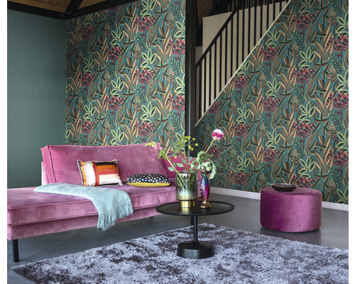 Wohnzimmer mit floral gemusterter Tapete, Sofa, Tisch und Teppich.