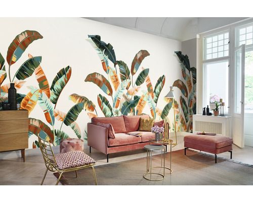 Wohnzimmer mit rosa Sofa, goldenem Stuhl und Fototapete mit Pflanzenmotiven