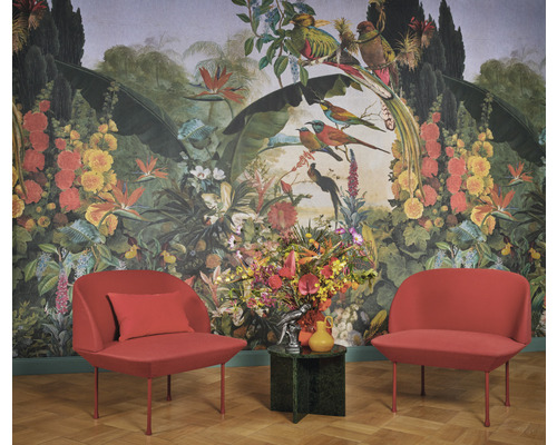 Raumgestaltung mit floraler Dschungeltapete, zwei Sesseln und einem Blumenarrangement auf einem Beistelltisch