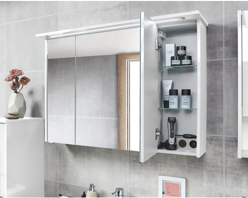 Spiegelschrank mit LED Beleuchtung und geöffneter Tür, Einblick auf Glasablagen und Badutensilien