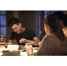 Personen sitzen am Esstisch und essen
