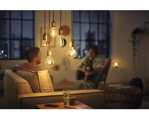 Wohnzimmer mit dekorativen Pendelleuchten und entspannten Personen