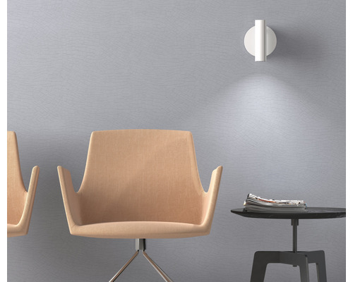 Szene mit zwei Stühlen, einem Tisch mit Zeitschriften und einer Wandleuchte