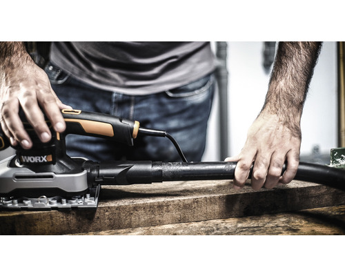 Mann schleift Holzbrett mit einem Schwingschleifer der Marke Worx