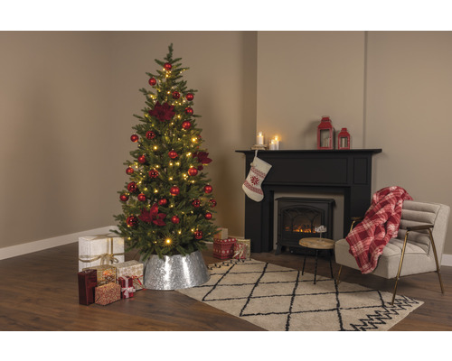 Weihnachtsbaum mit roter Dekoration und Geschenken im Wohnzimmer mit Kamin