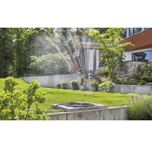 Gartenbewässerung mit Rasensprenger im grünen Garten