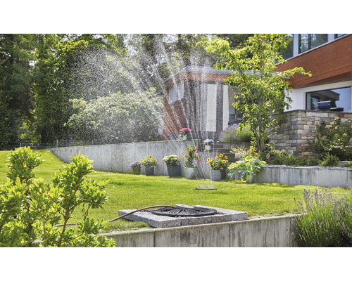 Gartenbewässerung mit Rasensprenger im grünen Garten